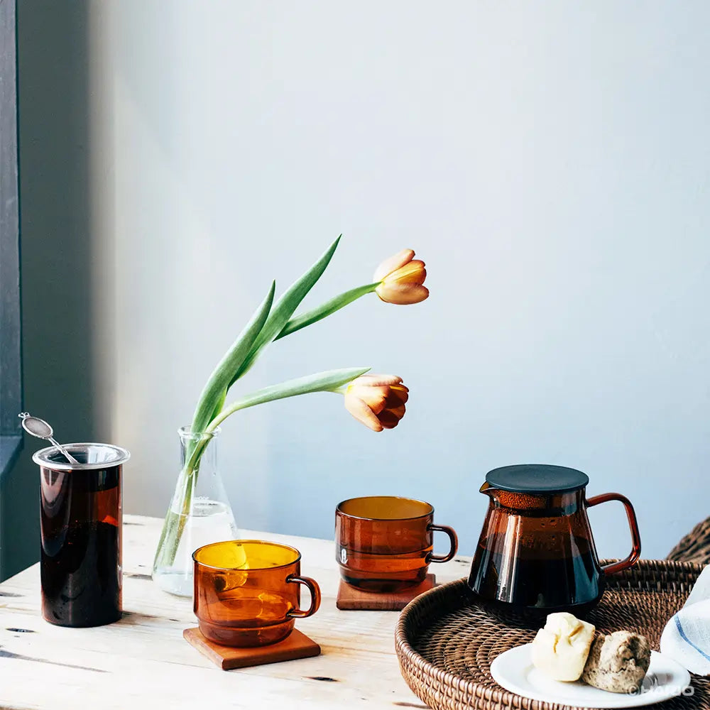 Lifestyle zdjęcie Hario Colors Tea & Coffee Server – bursztynowe szklane naczynia do parzenia kawy i herbaty na jasnym stole