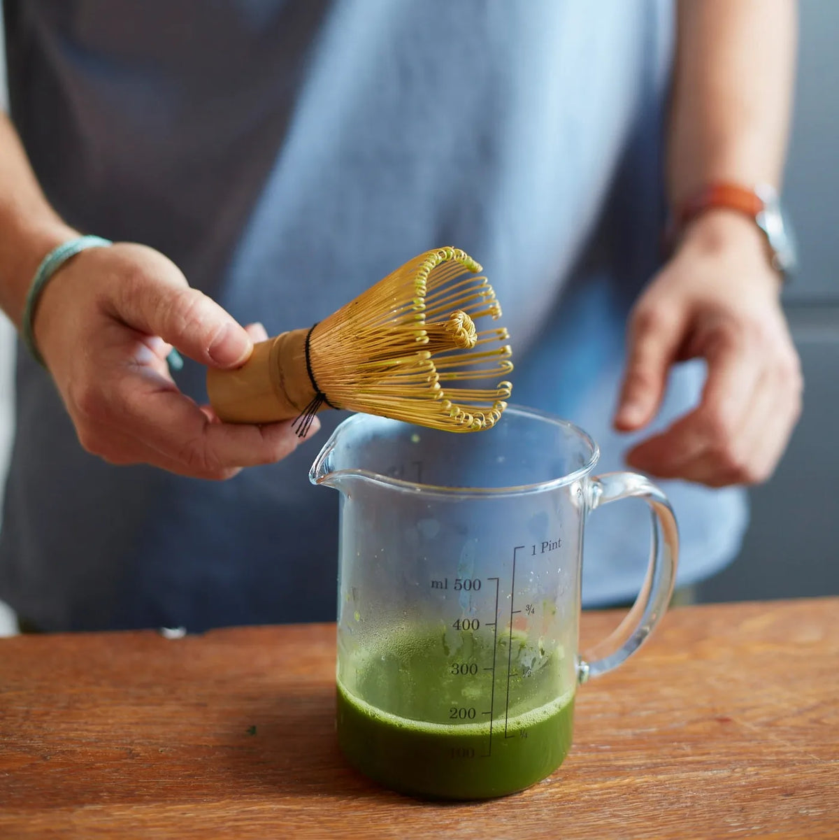 Bambusowa trzepaczka chasen do matchy podczas przygotowania napoju w dzbanku – mieszanie zielonej herbaty matcha w stylu barista