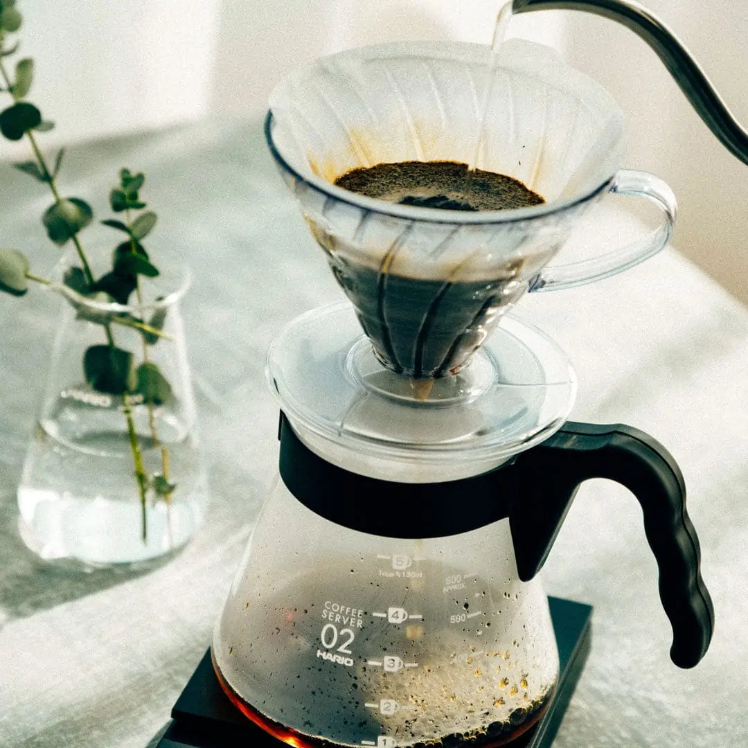Parzenie kawy przelewowej metodą V60 – dripper Hario na szklanym serwerze, proces zaparzania kawy specialty, zdjęcie lifestyle