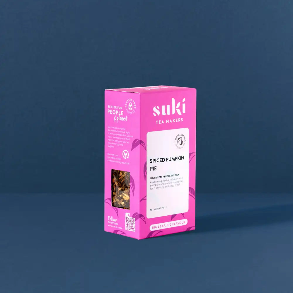 Herbata Suki Spiced Pumpkin Pie 45 g w różowym opakowaniu ustawiona na granatowym tle, widok pod kątem na pudełko.