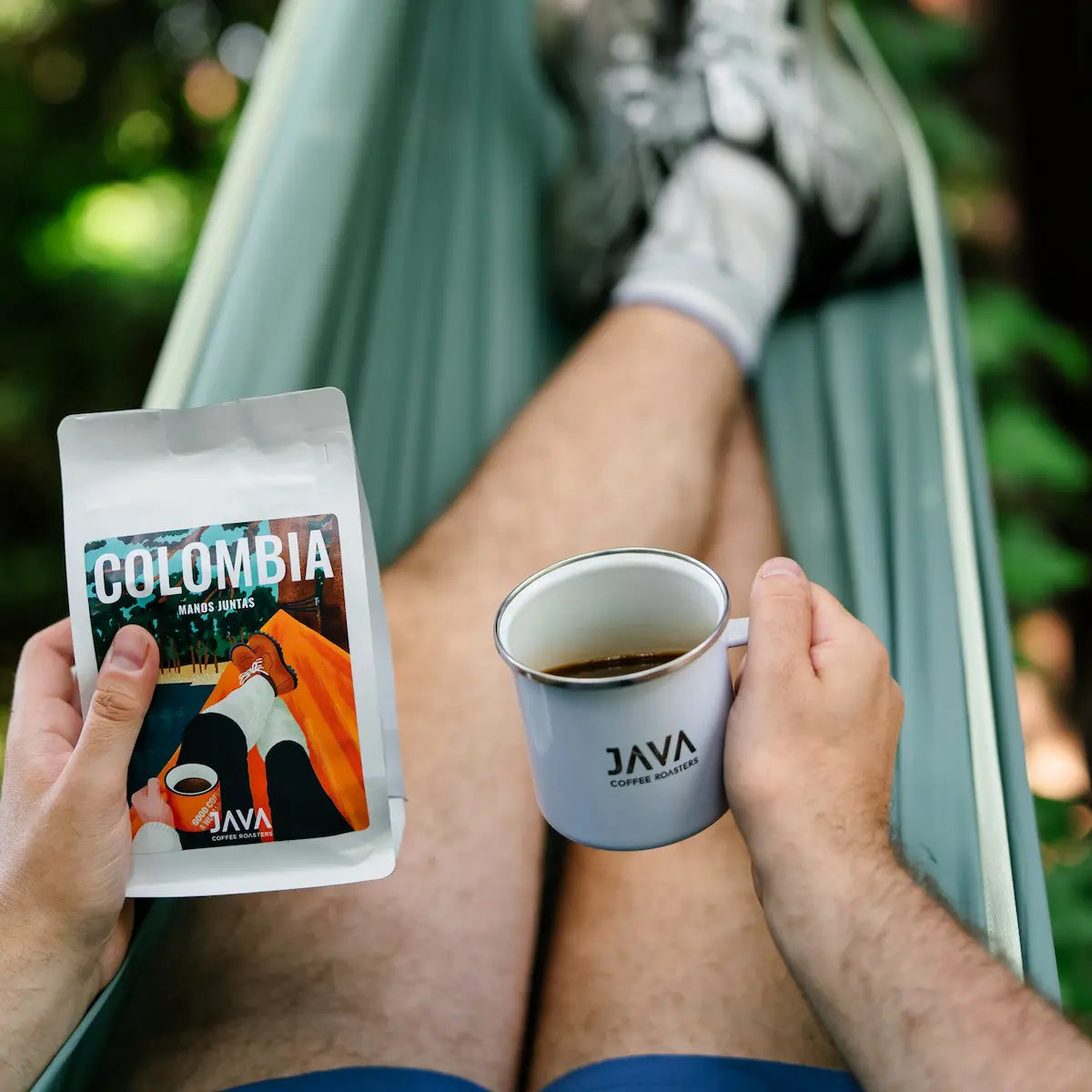 Świeżo palona kawa specialty Colombia Manos Juntas od JAVA Coffee Roasters z kubkiem czarnej kawy podczas relaksu w hamaku.