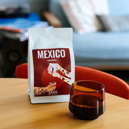 Kawa Mexico Ozolotepec od JAVA Coffee Roasters obok filiżanki świeżo zaparzonej kawy