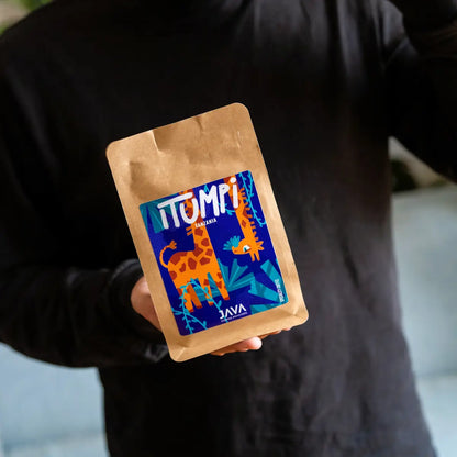 Dwie paczki kawy specialty Tanzania Itumpi od Java Coffee Roasters prezentowane w dłoniach
