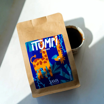 Kawa specialty Tanzania Itumpi 250 g od JAVA Coffee Roasters z filiżanką świeżo zaparzonej kawy w naturalnym świetle