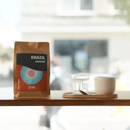 Kawa Java Coffee Roasters Brazil Maracanã w tle, dwa napoje na lodzie z miętą, cytryną i płatkami róż na drewnianej tacy

