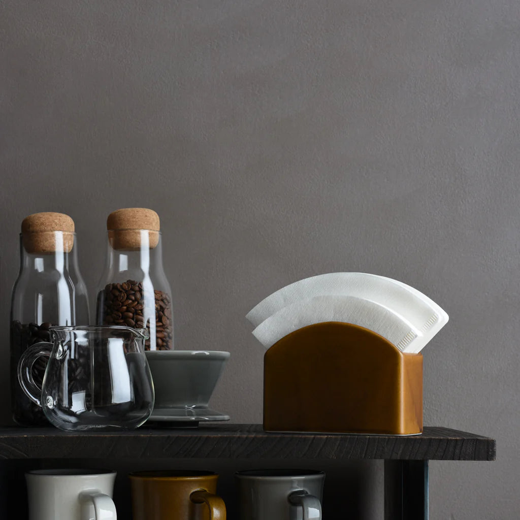 Filtry papierowe Kinto SCS na 4 filiżanki w ceramicznym pojemniku, obok akcesoriów do kawy