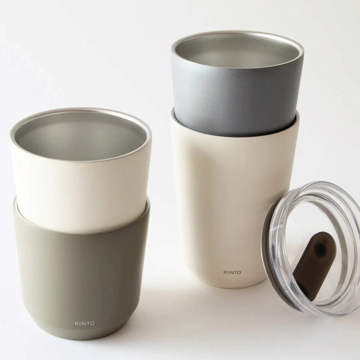 Kubki termiczne KINTO To Go Tumbler w różnych kolorach z przezroczystą pokrywką do picia.