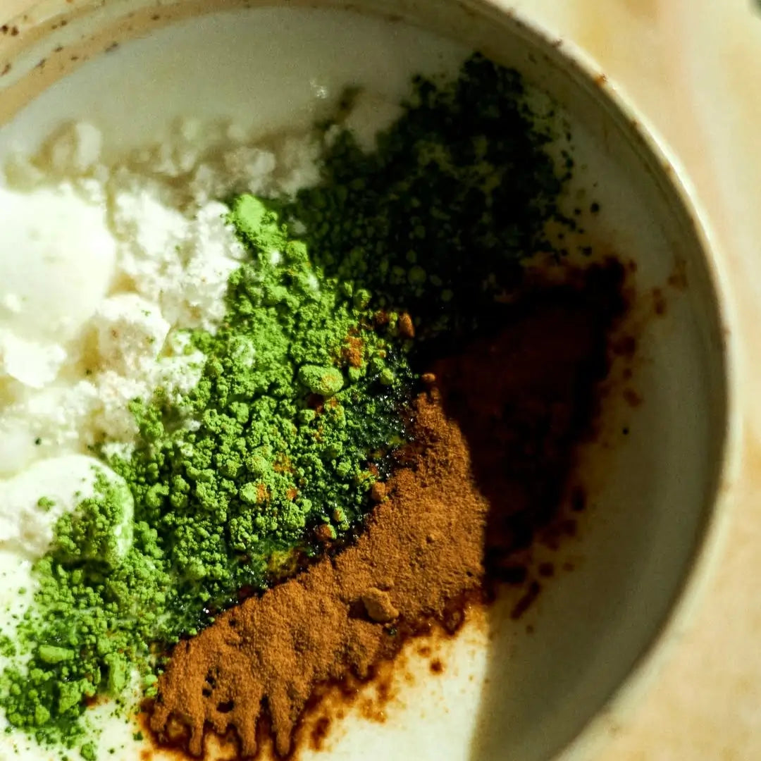 Składniki Shroom Matcha Latte – matcha, mleko kokosowe i Lion’s Mane w proszku z miarkami na drewnianym tle